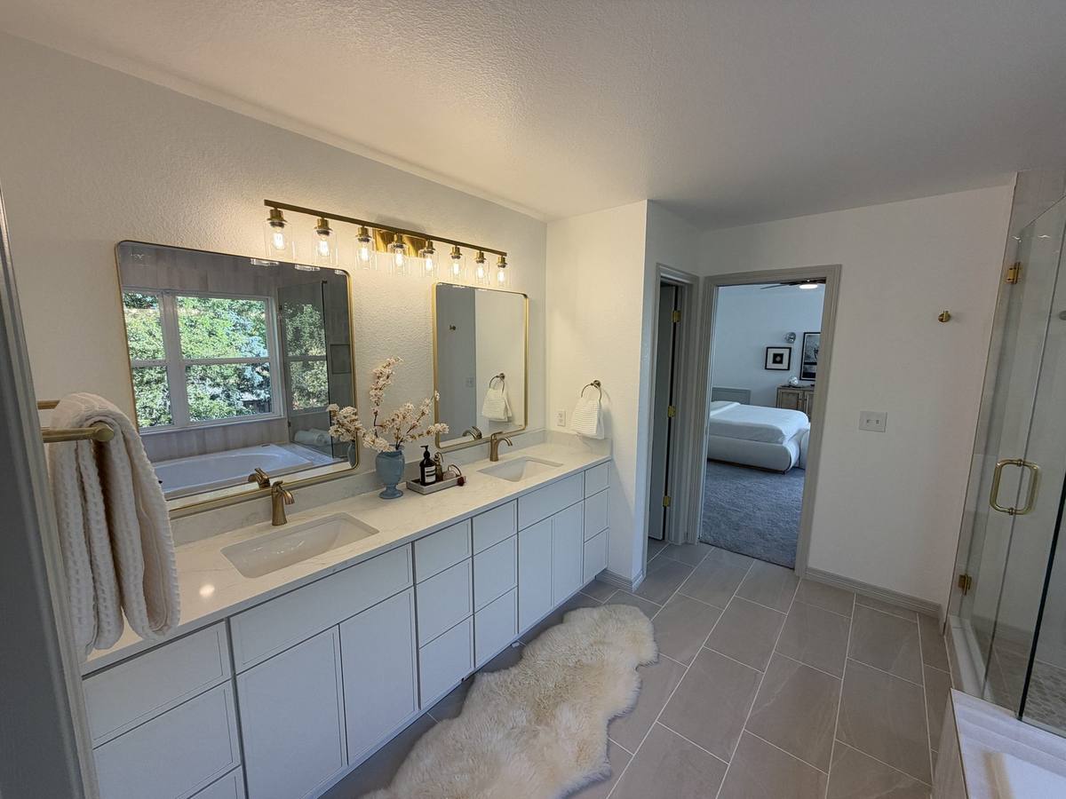 Double vanity bathroom remodel with gold fixtures — Denver by Gribbons Group Corp